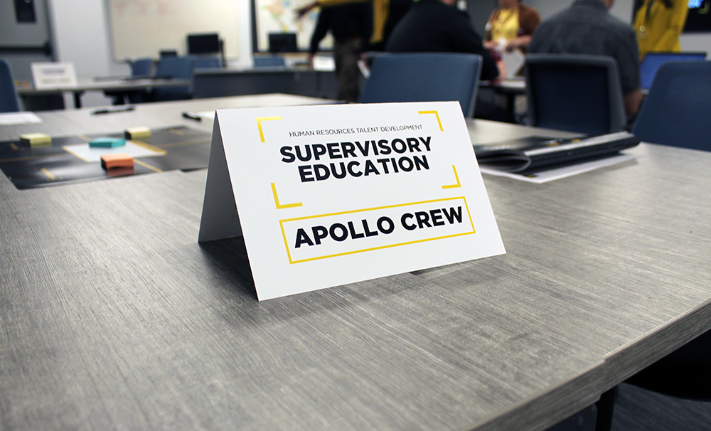 Classroom table showcasing one of the Supervisory Education class teams, the "Apollo Crew."