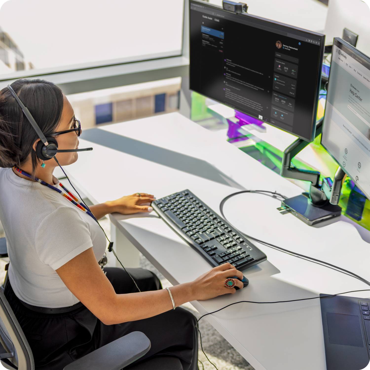 Computer Keyboard, Table, Adult, Female, Person, Woman, Desk, Monitor, Headphones, Bracelet