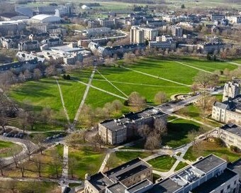 Aerial photo of Virginia Tech campus showing grey Hokie Stone buildings surrounding the green Drillfield.