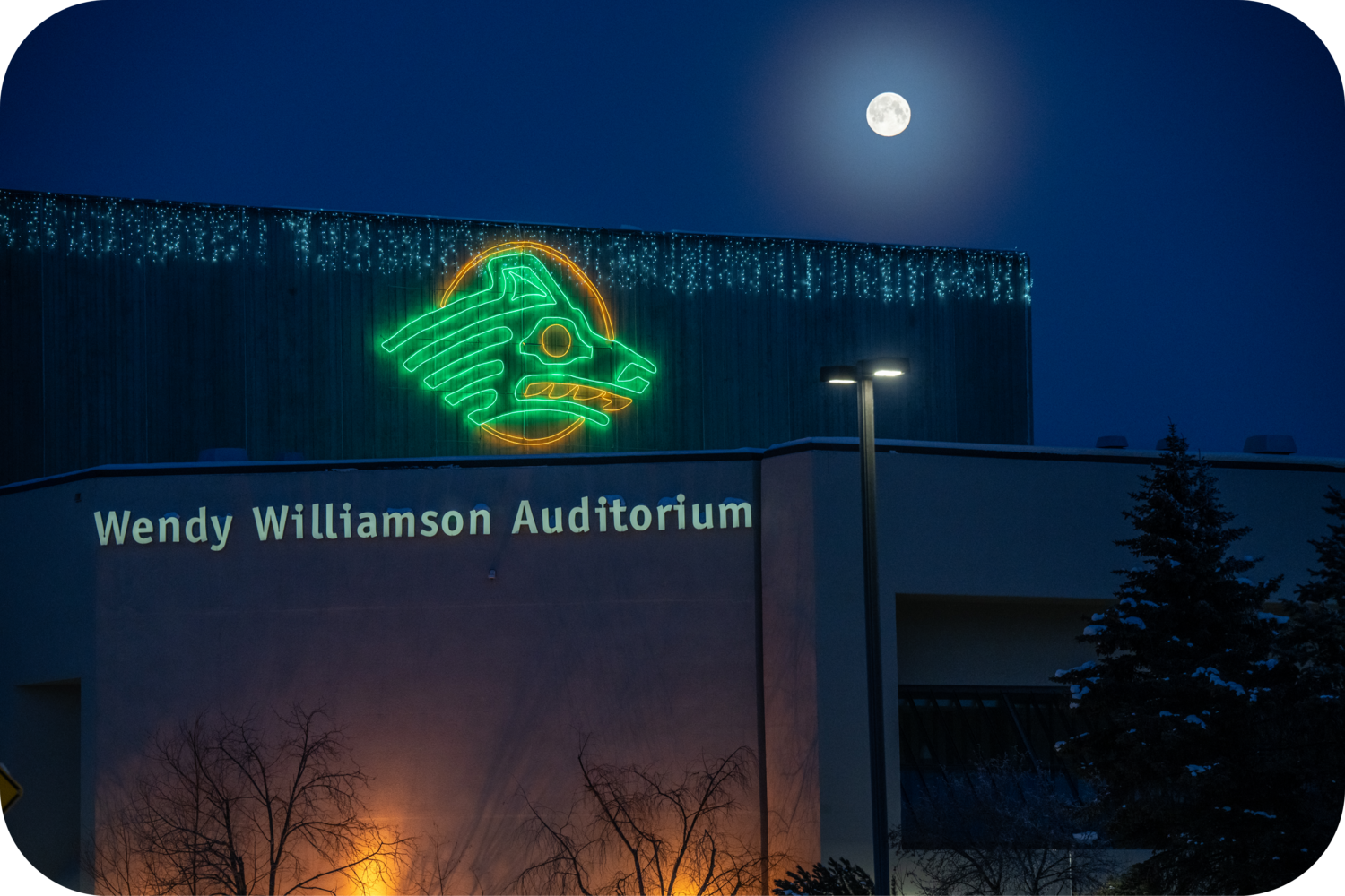 University of Alaska Anchorage campus at night with moon in the sky.  