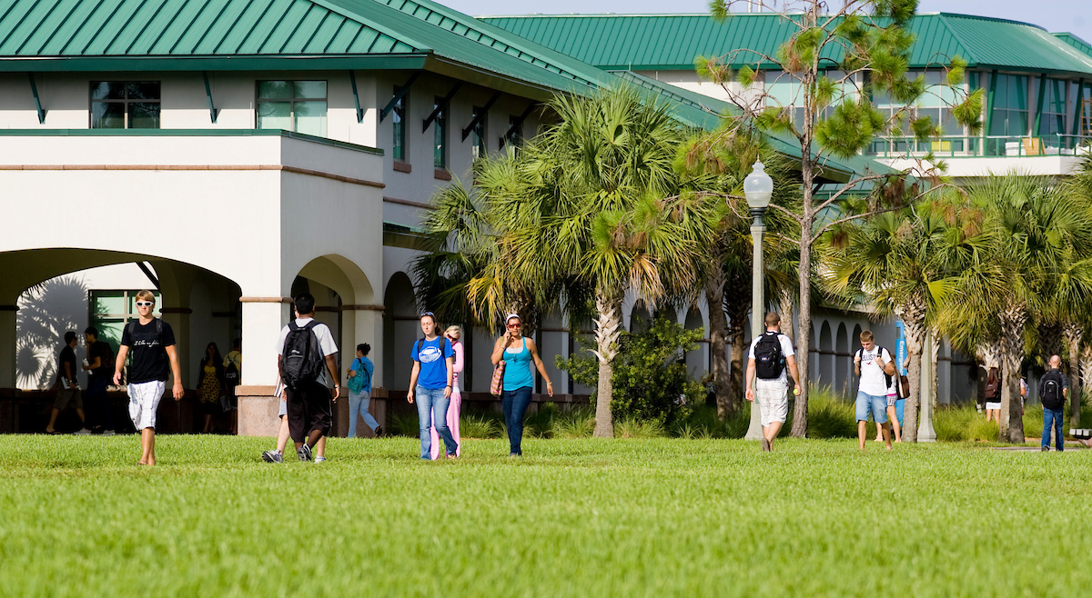 Grass, Person, Walking, Lawn, Building, Campus, Shorts, Hotel, Tree, Jeans