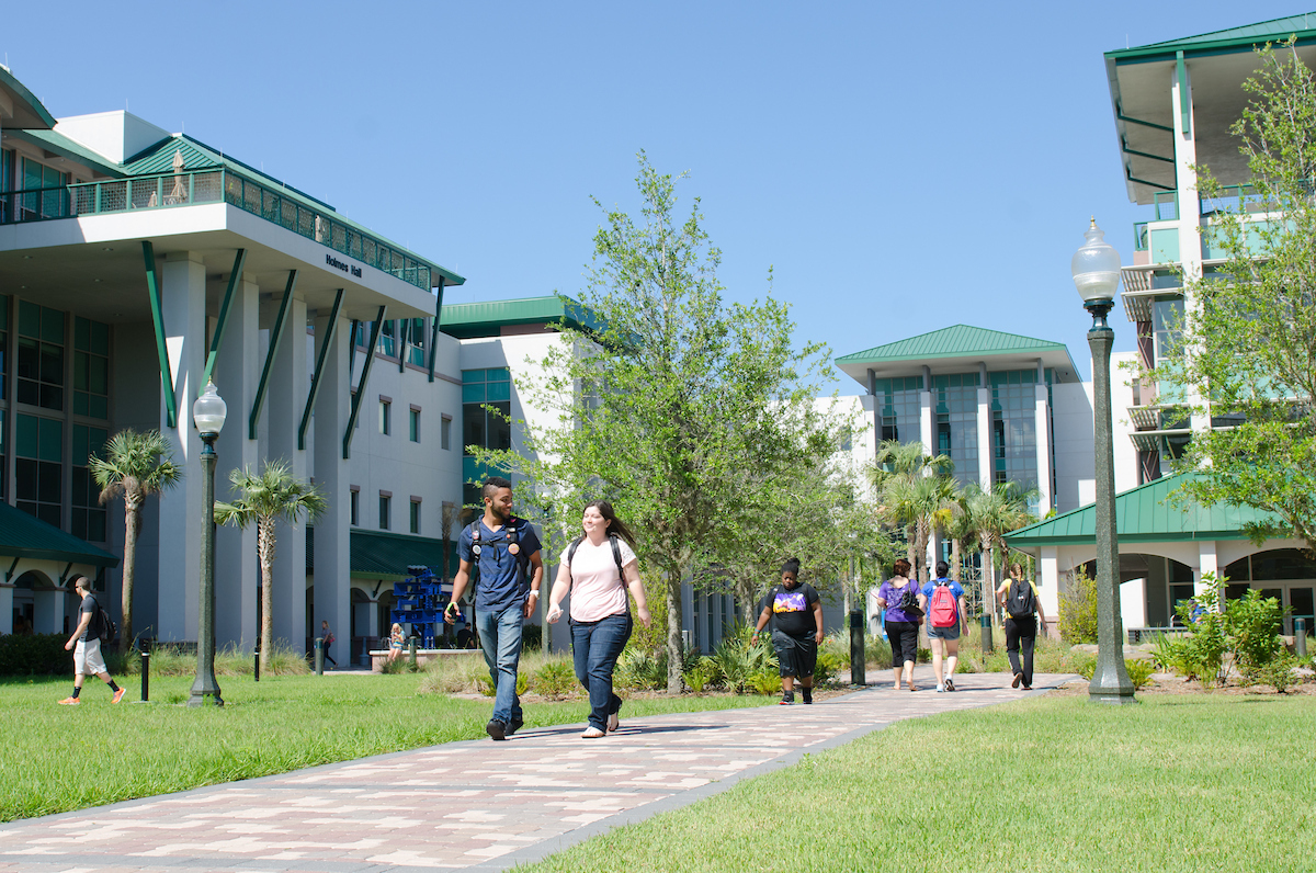 Person, Walking, Architecture, Building, College, Campus, Jeans, Pants, Grass, Shoe