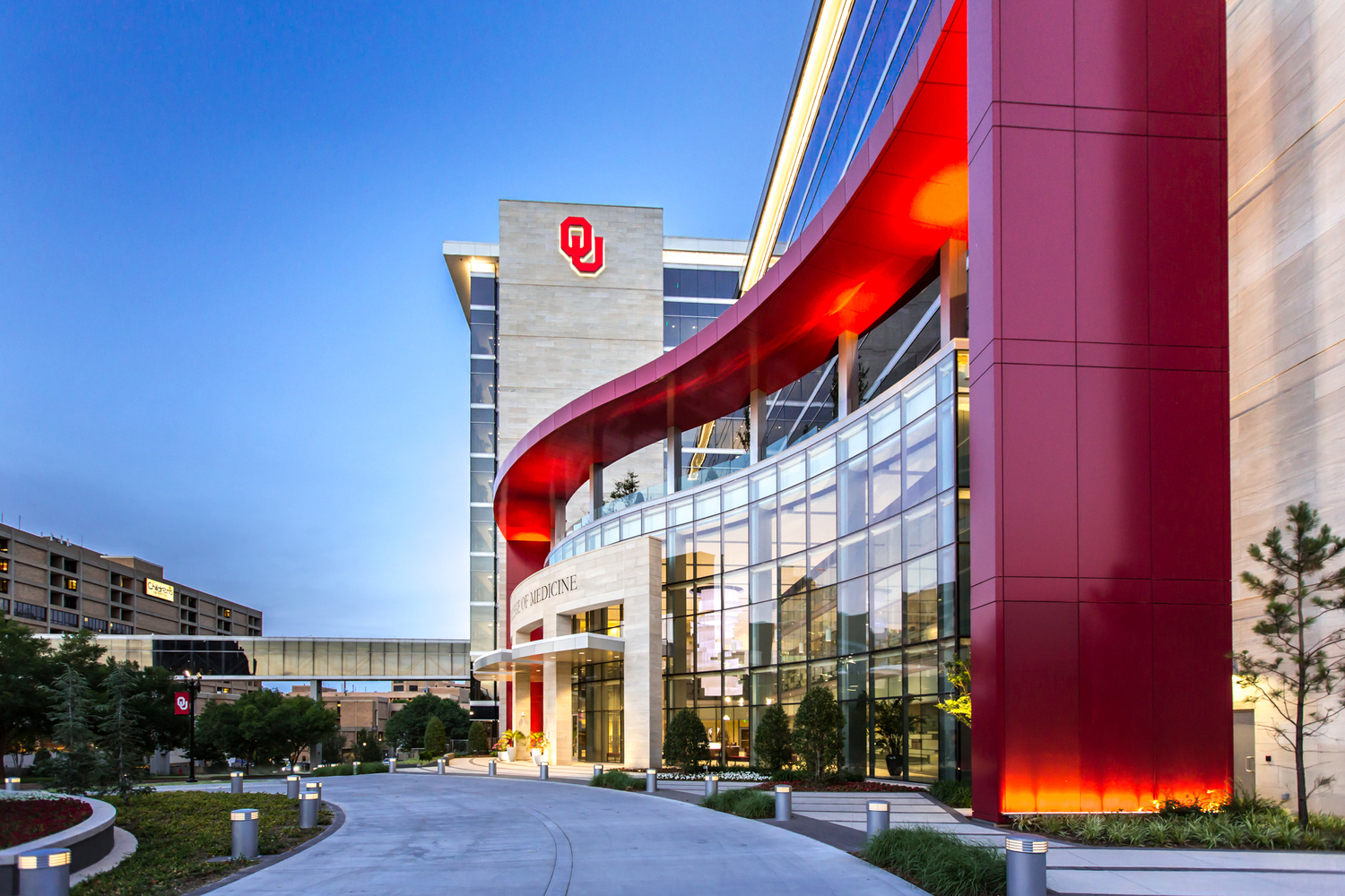 A modern OU campus building with a curved red architectural feature and large glass windows.