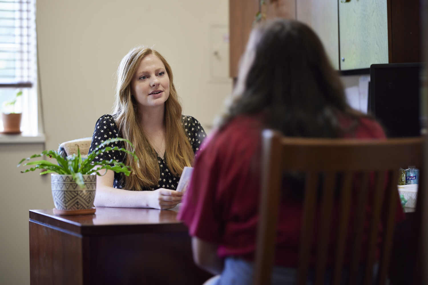 Two people sit across a desk with papers, and the words “PEAK TEMPORARY STAFFING” appear across the image.